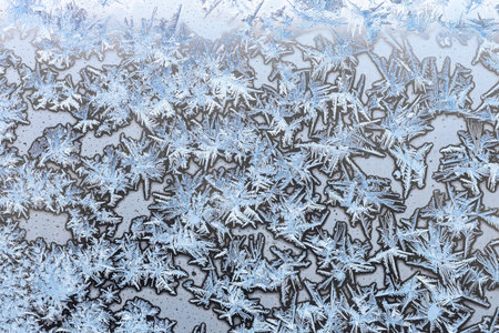 horizontal natural background - blue frozen ice on surface on home window glass close up on cold...