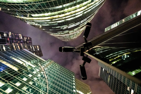 bottom view of outdoor security cameras between skyscrapers at night