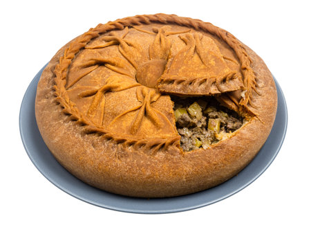 Tatar cuisine - open Zur Belish Tatar Big Pie (close baked pie from unleavened dough with meat and potato fillings) on plate isolated on white backgroundの写真素材