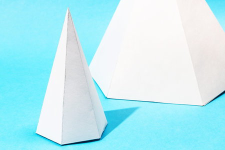 handmade paper pyramids close up on turquoise blue background