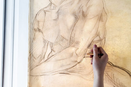 artist copies pencil drawing on window glass