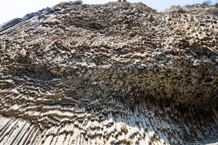 symphony of the stones - bottom view of walls from natural basalt columns in Garni gorge in Armenia...