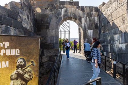 Garni, Armenia - September 30, 2023: tourists near gate to entrance to Garni Temple museum area in Armenia on autumn dayのeditorial素材