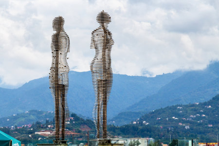 Batumi, Georgia - September 16, 2023: Statue of Man and Woman (Ali and Nino) and clouds over mountains on background in Batumi city on autumn day. Statue was made by Georgian artist Tamara Kvesitadzeのeditorial素材