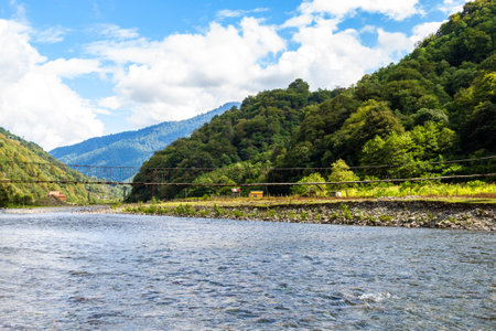 travel to Georgia - Machakhelistsqali river with suspension bridge in mountain in Adjara on sunny autumn dayの写真素材