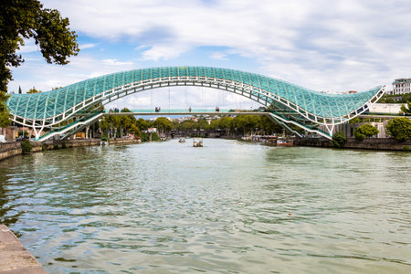 Tbilisi, Georgia - September 26, 2023: view of modern Bridge of Peace across Kura River in Tbilisi city on cloudy autumn dayのeditorial素材