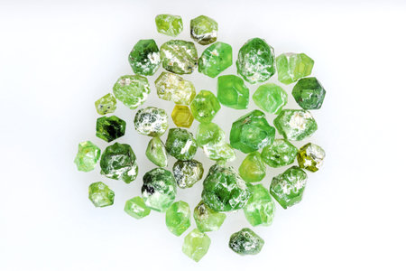 close up of sample of natural stone from geological collection - many unpolished demantoid crystals on white background from Ural Mountainsの写真素材