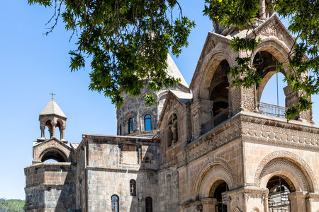 green tree branches and Etchmiadzin Cathedral in Etchmiadzin, Vagharshapat city, Armenia on sunny summer day. Cathedral was listed as World Heritage Site by UNESCOの写真素材
