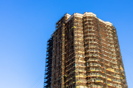 sunlit brick high-rise apartment building under renovation in autumn sunsetの写真素材
