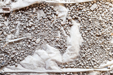 above view of gray expanded clay on polyethylene film on floor of attic in village houseの写真素材