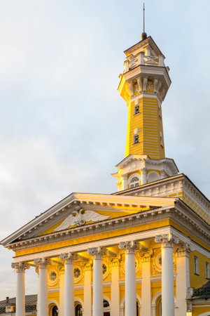building of fire-observation watchtower on Susaninskaya Square, symbol of Kostroma city lit by setting sun at winter sunsetの写真素材