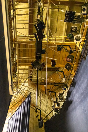 electric lights and spotlights on ceiling behind curtain of theater stageの写真素材