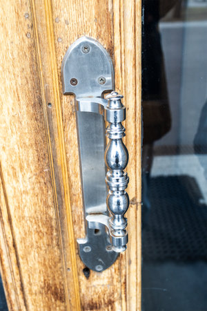 polished steel door handle on old open wooden door close upの写真素材