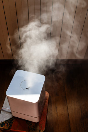 evaporating water by household humidifier in living room next to heating radiator