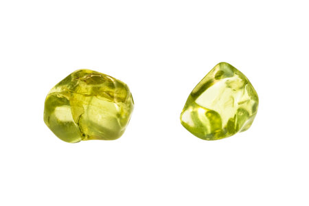 close up of sample of natural stone from geological collection - two tumbled peridot minerals isolated on white backgroundの写真素材