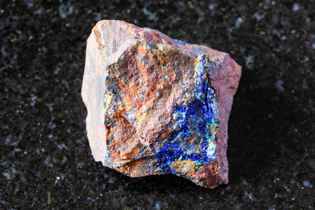 sample of raw zarinite mineral on black granite background close up from Altai, Russia