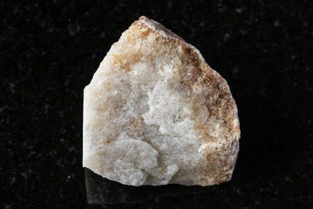 sample of raw brown quartzite mineral on black background close up