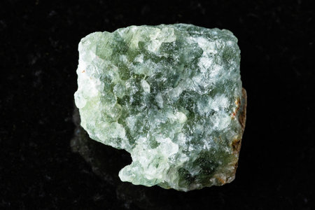 sample of uncut green aventurine mineral on black background close up