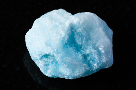 sample of raw blue aragonite mineral on black background close up