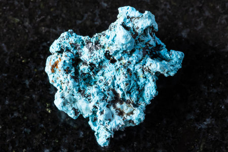 sample of raw shattuckite mineral on black granite background close up from Katanga, Congo