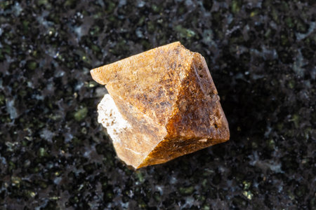 sample of rough zircon crystal on black granite background close up from Khibiny, Kola Peninsula, Russiaの写真素材