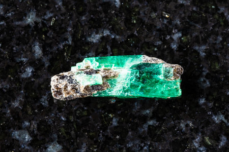 sample of raw emerald crystal on black granite background close up from Middle Urals, Russiaの写真素材