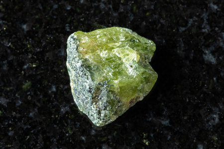 sample of raw green sphene mineral on black granite background close up from Pakistanの写真素材
