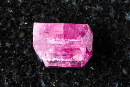 sample of raw rubellite crystal on black granite background close up from Transbaikalia, Russiaの写真素材