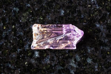 sample of rough purple scapolite crystal on black granite background close up from Tajikistanの写真素材
