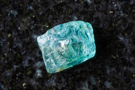 sample of raw starlite blue zircon mineral on black granite background close up from Cambodiaの写真素材