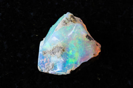 sample of raw ethiopian opal mineral on black granite background close up from Ethiopiaの写真素材