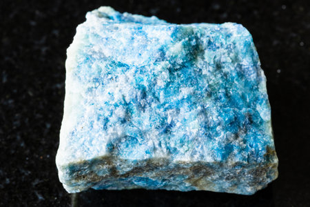 sample of rough lazurite (lapis lazuli) rock on black granite background close up from Pamirの写真素材