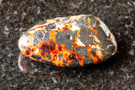 sample of polished franklinite and zincite minerals on black granite background close up from New Jersey, USAの写真素材