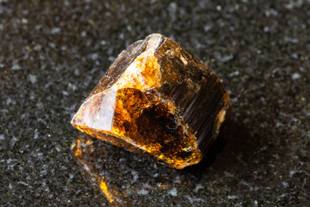 sample of rough dravite tourmaline rock on black granite background close up from Madagascarの写真素材