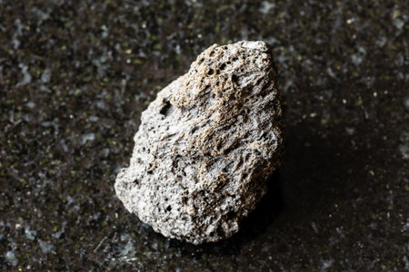 sample of raw pumice volcnic lava stone on black granite background close up from Sicilyの写真素材