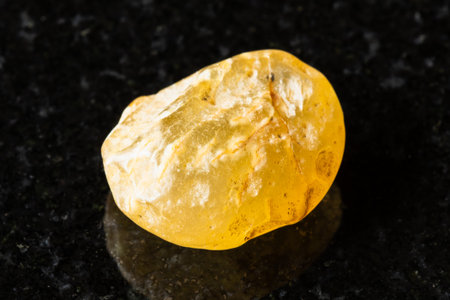 sample of raw cornelian stone on black granite background close up from Mongoliaの写真素材