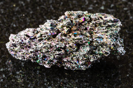 sample of raw carborundum (synthetic silicon carbide analog of moissanite) rock on black granite...