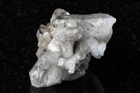sample of rough druse of clear quartz crystals on black granite background close upの写真素材