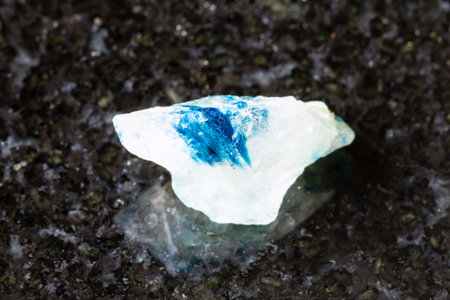 sample of rough euclase crystal on black granite background close up from Zimbabweの写真素材