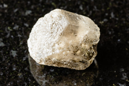 sample of raw phenakite rock on black granite background close up from Middle Urals, Russiaの写真素材