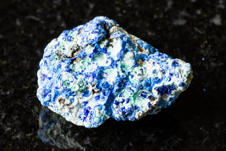 sample of rough azurite and gibbsite rock on black granite background close up from Russiaの写真素材