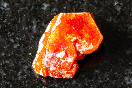 sample of rough vanadinite crystal on black granite background close up from Mibladen, Moroccoの写真素材