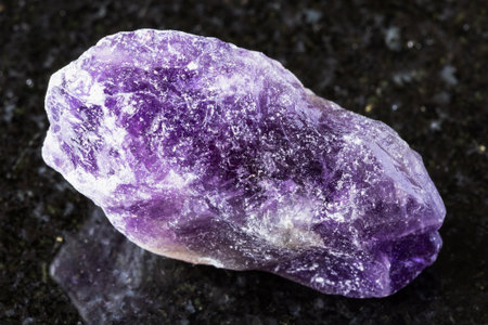 sample of uncut amethyst rock on black granite background close upの写真素材