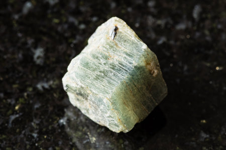 sample of rough green sapphire corundum rock on black granite background close up from Madagascarの写真素材