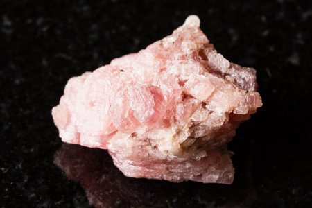 sample of rough rhodochrosite rock on black granite background close up from Guangxi, Chinaの写真素材