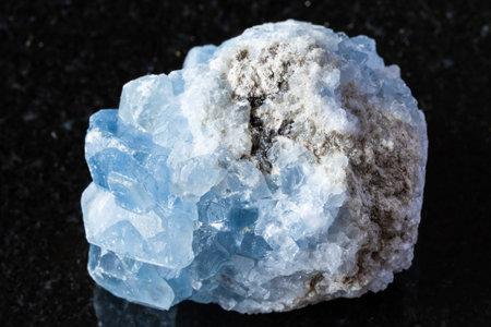 sample of raw celestite mineral on black granite background close up from Madagascar