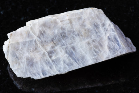 sample of raw belomorite moonstone rock on black granite background close up from North Karelia, Russiaの写真素材