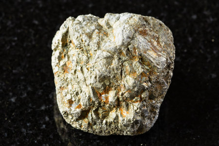 sample of unworked pyrite mineral on black granite background close up from Russiaの写真素材