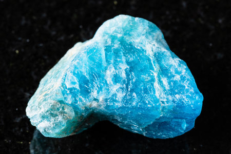sample of raw apatite rock on black granite background close up from Russiaの写真素材
