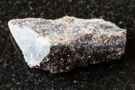 sample of raw phlogopite rock on black granite background close up from Kola Peninsula, Russiaの写真素材